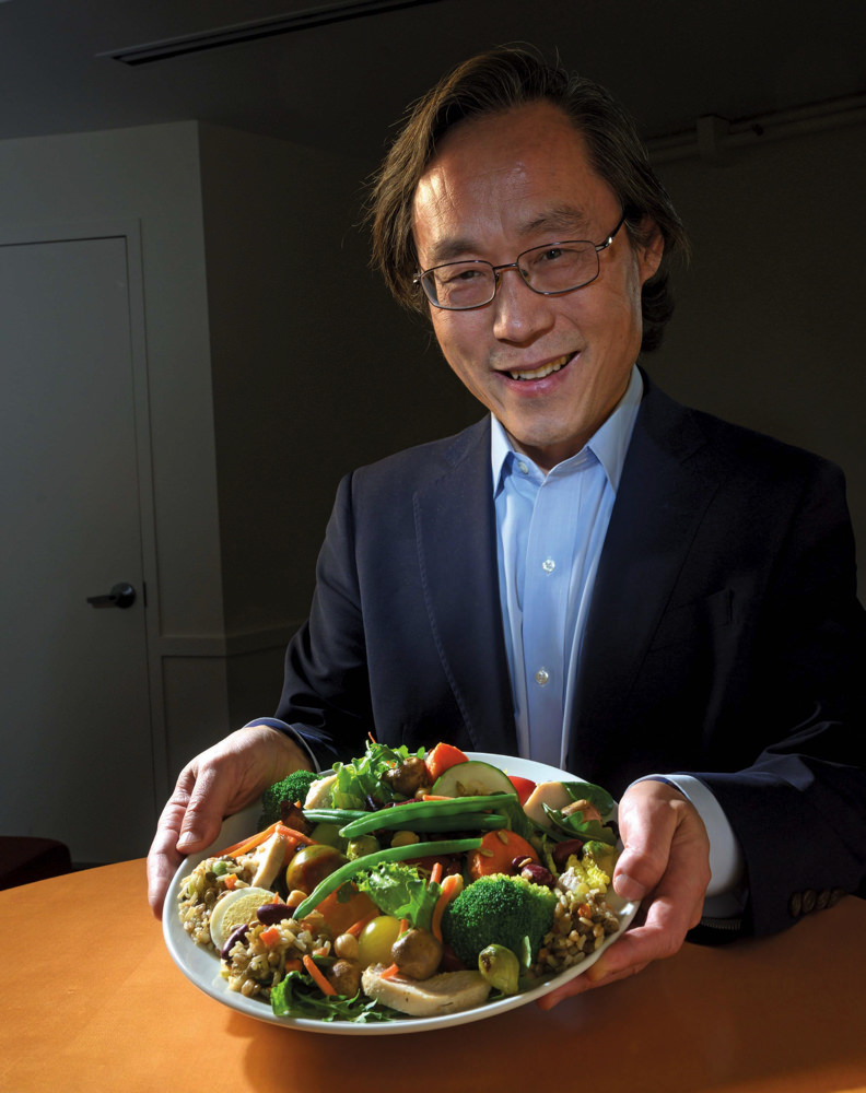 Dr. Frank Hu holding a plate vegetables.
