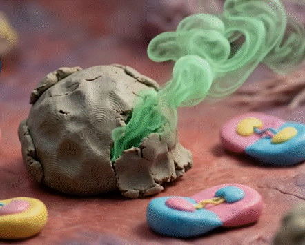 An artistic rendition of a non-proliferating senescent cell (grey cell) emitting SASP factors (green smoke) alongside other normal cells undergoing replication (blue, pink, and yellow caricatures)